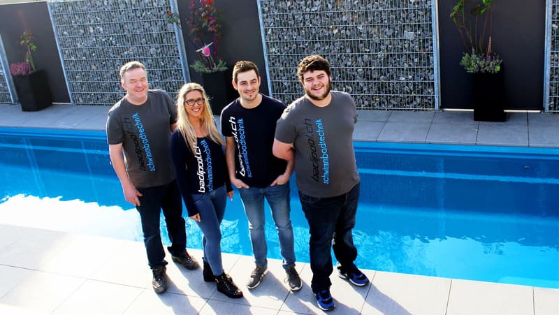 Badipool-Team in Firmen-T-Shirts am Poolrand