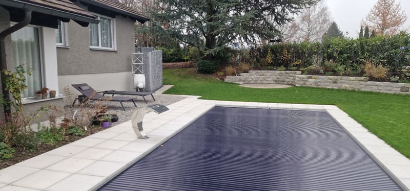 Pool mit Rollladen-Abdeckung im Garten eines Einfamilienhauses – ein Badipool-Projekt
